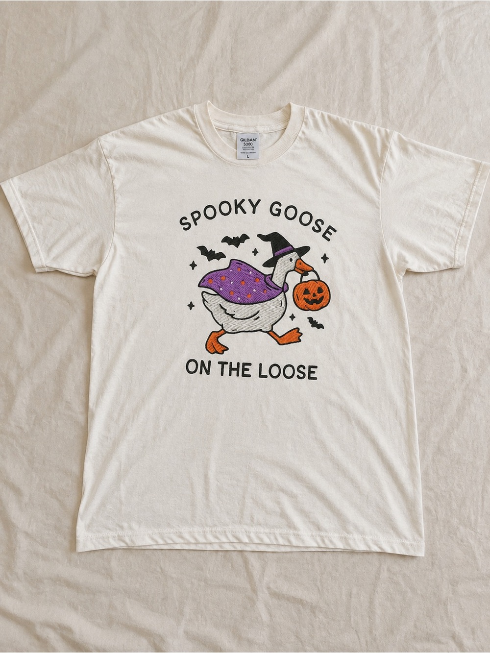 White Halloween Goose Tee with Purple Cape and Orange Pumpkin